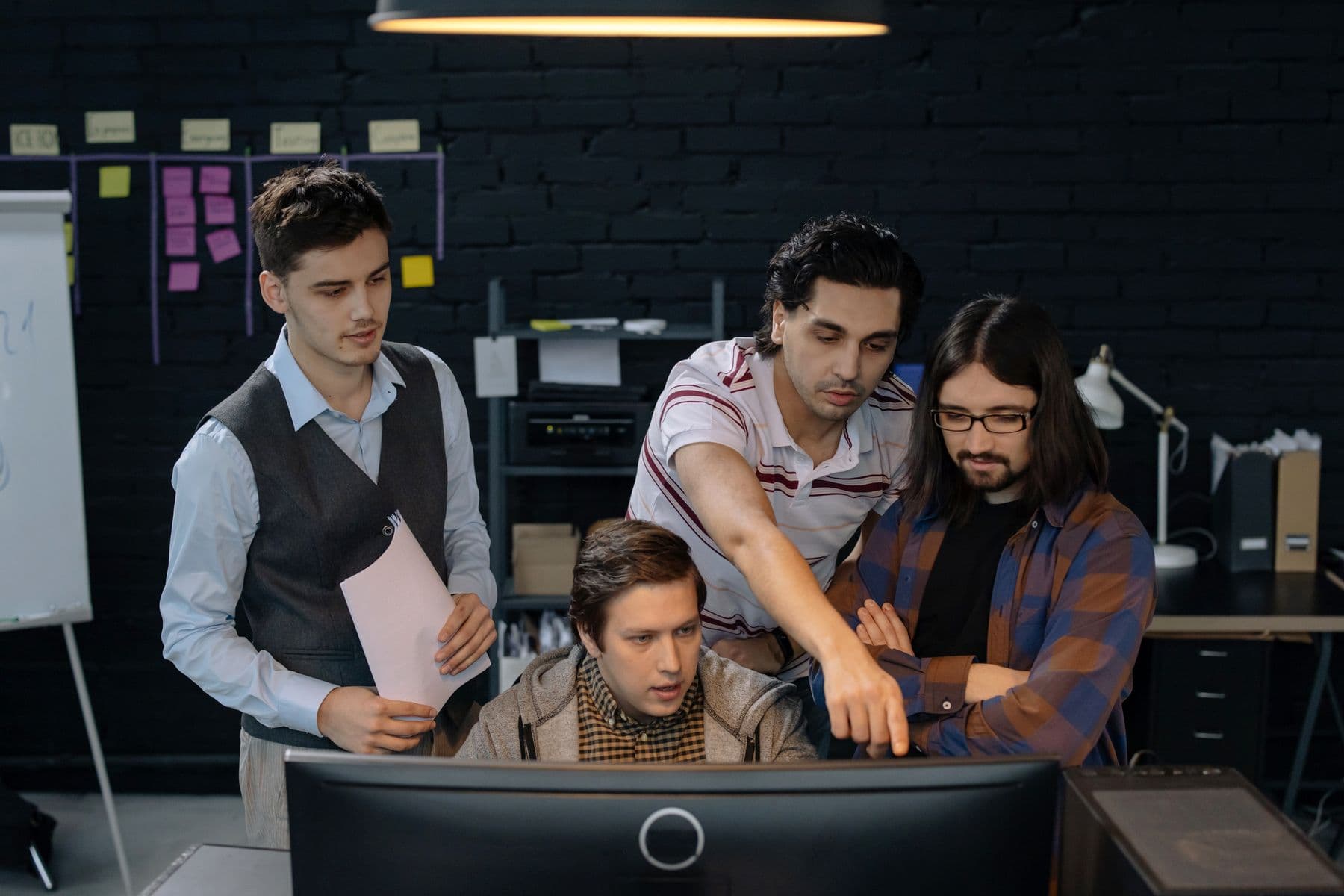 Team gathered around a monitor planning a system